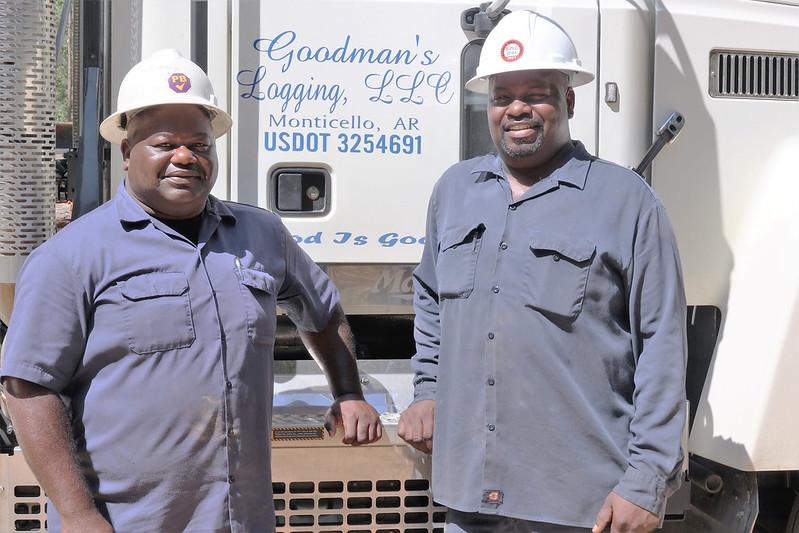 Reggie, l, and Chris, r, Goodman standing in front of one of their logging trucks.