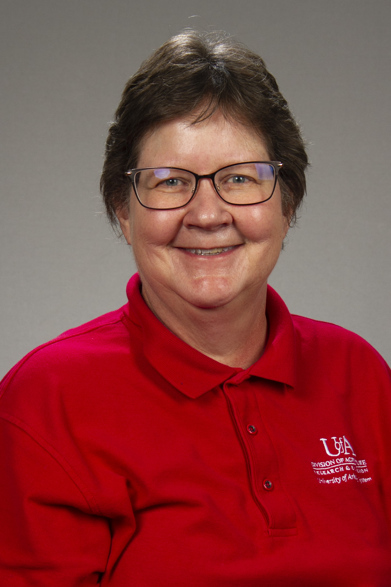 Portait of a woman with a red polo shirt and short hair