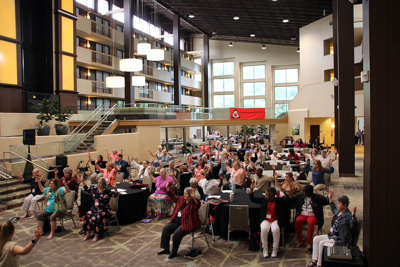 Extensions Homemakers participate in a chair yoga exercise.