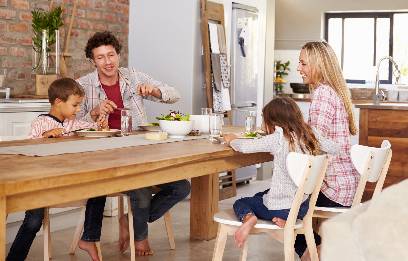 family of four eating dinner at the kitchen table