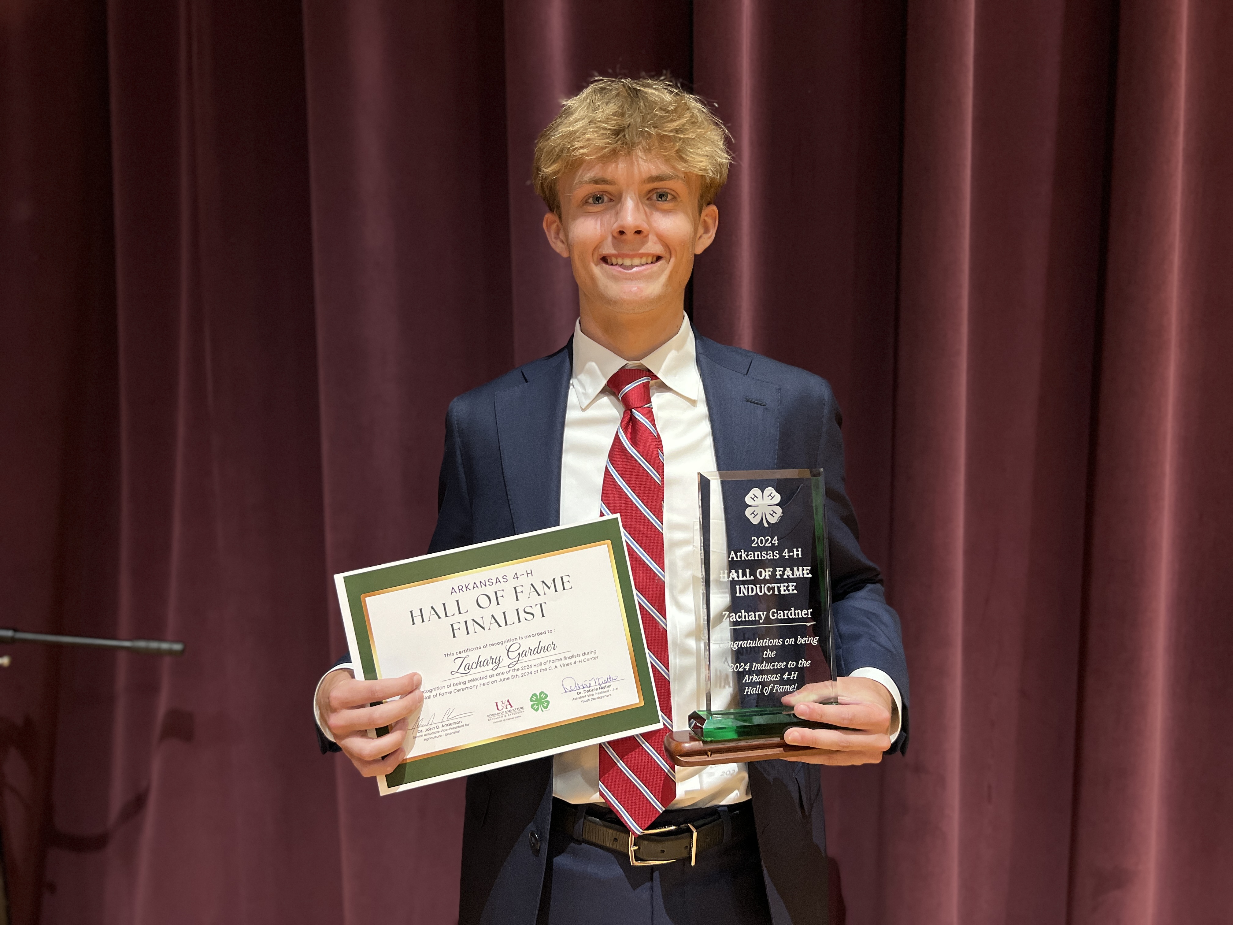 Zach Gardner holding Hall of Fame plaque and certificate