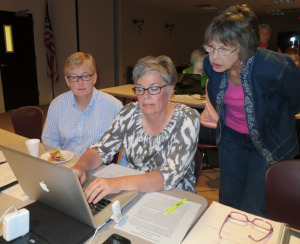 Master gardener volunteers working at a computer